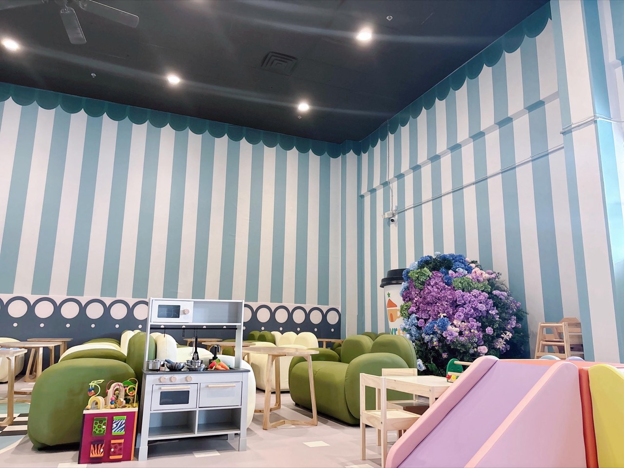 Cozy cafe lounge with green seating and striped walls